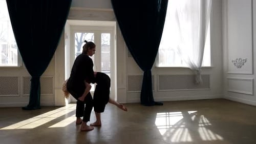 Ballet Dancers are Rehearsing Contemporary Choreography in Hall Man is Holding Woman and Putting on