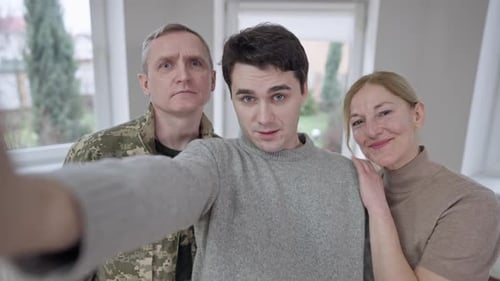 Smiling Family Poses Together for Selfie Indoors