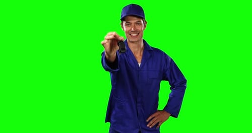 Front view of mechanic giving car keys with green screen