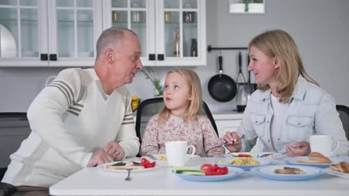 Family of Three Eating Breakfast Together at Table