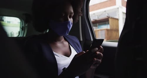 Mujer afroamericana con máscara facial en el coche