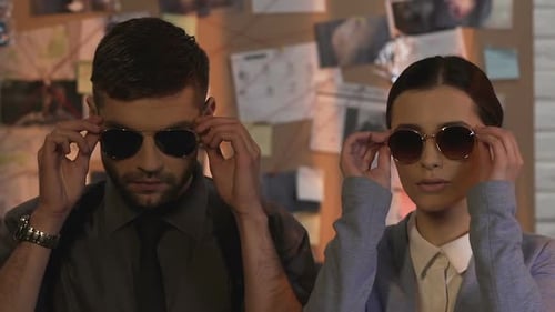 Serious Investigators Putting on Sunglasses in Office