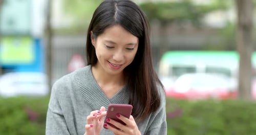 Young Woman Using Smartphone in Urban Setting