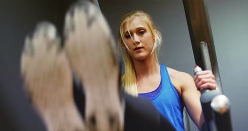 Young Woman Exercising in Gym on Machine