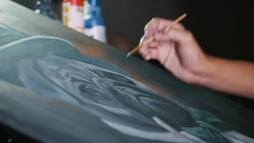 Artist Painting Gray Portrait on Canvas with Brush