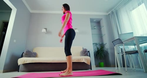 Woman Doing Squats on Yoga Mat at Home