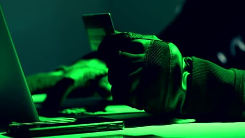 Conceito de roubo de cartões de crédito. Hacker com cartões de crédito em seu laptop