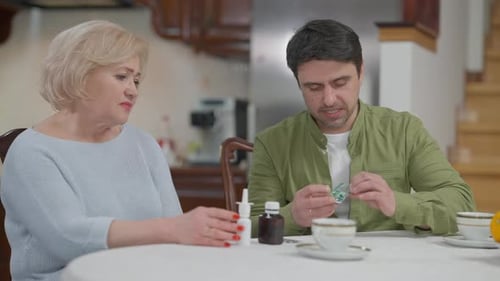 Woman and Man Discussing Medicine Prescriptions at Home