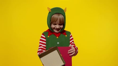 Excited Boy Dressed as Elf Opens Christmas Gift