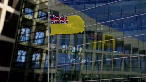 Waving Niue Flag on Flagpole in Front of Corporate Building