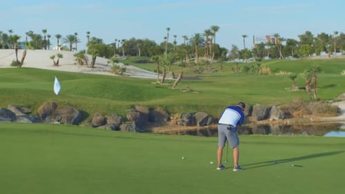 Golfer Putting on Green Tropical Golf Course