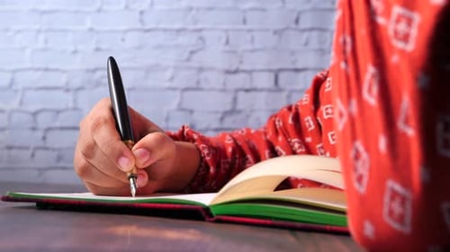 Close Up of Women Hand Writing on Notepad
