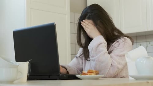 Woman Working on Laptop in Kitchen at Home