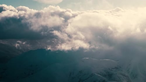 Mountains Covered in Snow and Overcast by Clouds