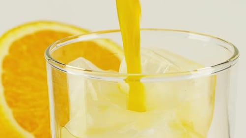 Refreshing Orange Juice Poured Into Glass with Ice