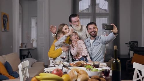 Family Smiles and Poses for a Smartphone Selfie