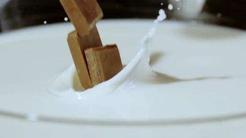 Chocolate Piece Falling into White Milk in Slow Motion