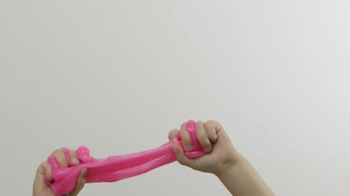 Child Hands Playing Oddly Satisfying Pink Slime on White Background. Antistress