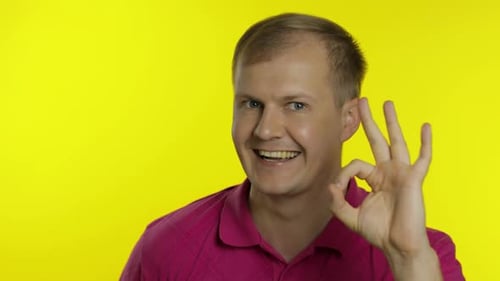 Man Smiling and Giving Okay Gesture on Yellow