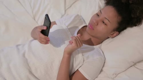 Woman Lying in Bed Using Smartphone