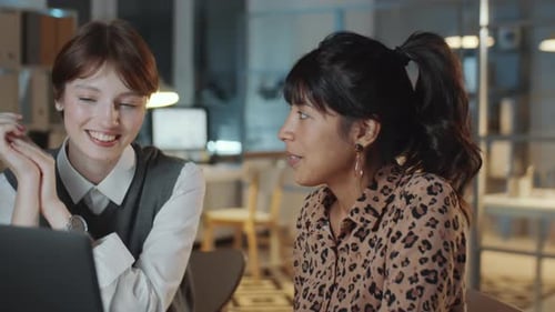 Two Young Multiethnic Businesswomen Working Late in Office