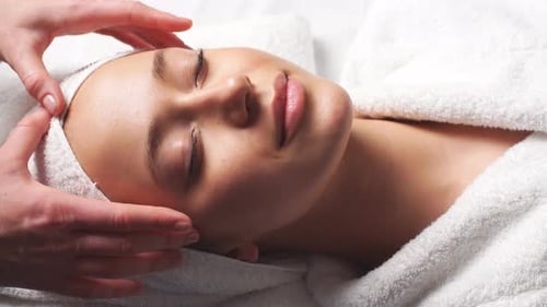 Spa Damen Gesichtsmassage. Gesichtsmassage im Beauty-Spa-Salon. Frau genießt entspannende Gesichtsmassage