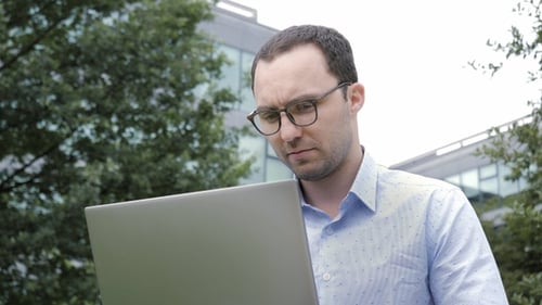 Happy Man Sitting on Bench and Using Laptop in A Park.