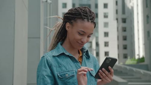 Young Woman Using Phone Outside in City