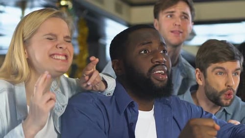 Multiethnic Sport Fans in Bar Disappointed About Favorite Team Losing Match