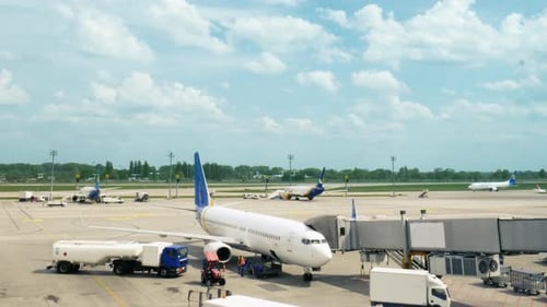 Airport Employees Preparing the Plane Before the Flight. Aircraft with Blue Sky on the Background