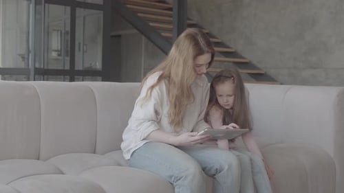 Woman and Child Looking at Tablet Device Together