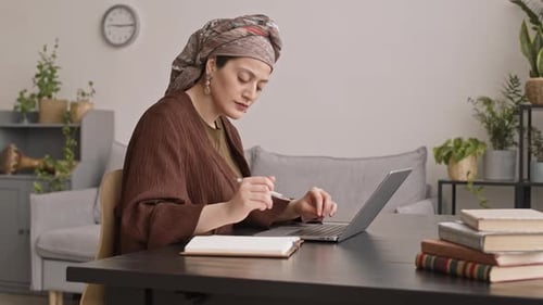 Woman Works on Laptop at Home Desk