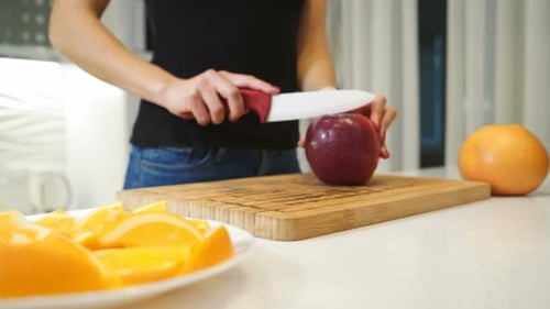 Woman Slicing an Apple in Kitchen
