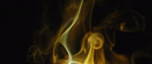 Goldene Weihrauchflammen wirbeln auf schwarzem Hintergrund
