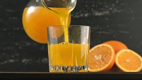 Refreshing Orange Juice Being Poured in Glass