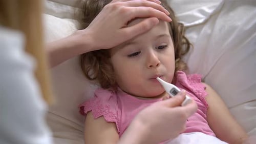 Frau misst die Temperatur von Little Girl