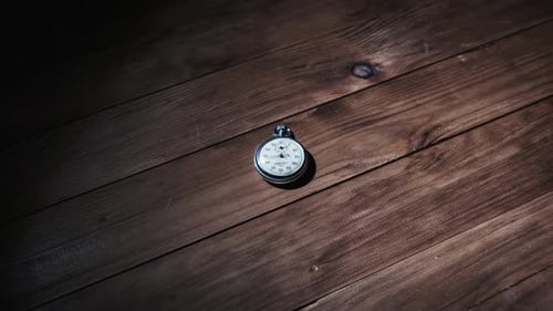 An Antique Stopwatch Lies on Wooden Table and Counts the Seconds Timelapse