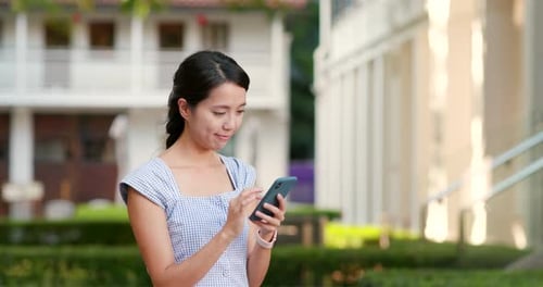 Young Woman Using Smartphone in Urban Park