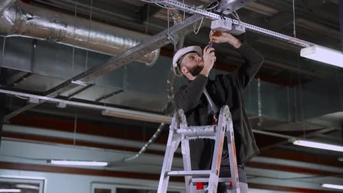 Electrical Works in Industrial Premises Electrician is Installing Junction Box