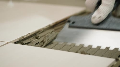 Tiling Work with Adhesive on White Tile Floor