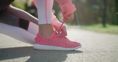 Handheld view of woman’s hands tying her sports shoes