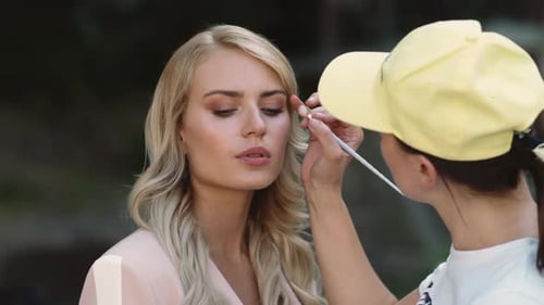 Closeup Model Preparing for Filming. Make Up Artist Doing Makeover at Street