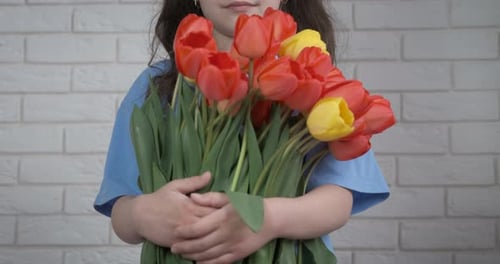 Little Girl Holding Bouquet of Tulips in Home