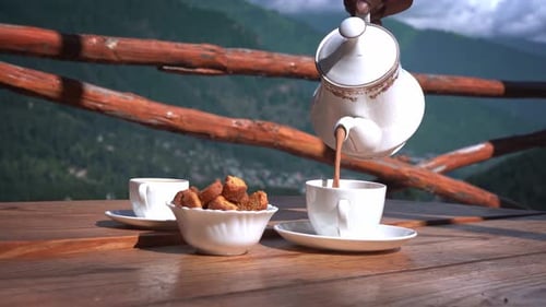 Pouring Tea Outdoors with a Mountain View