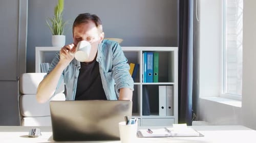 Young male entrepreneur works at home office at the computer.