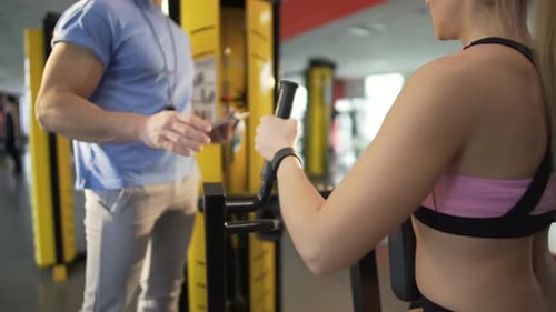 Fitness Coach Helping Female Client Do Exercises in Gym, Healthy Lifestyle