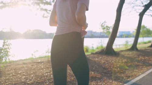 Asian young beautiful sport woman running on street in public park.
