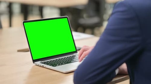 Typing on Laptop with Green Screen in Office