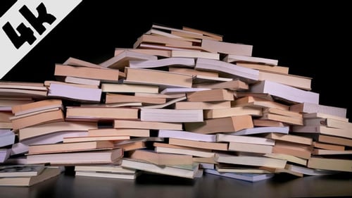 Growing Stack of Books Pile on Dark Background