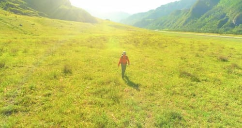 Flight Over Backpack Hiking Tourist Walking Across Green Mountain Field
